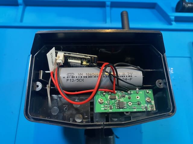 Open jank node: 18650 cell, RF module, charging board, and wiring on a blue work mat